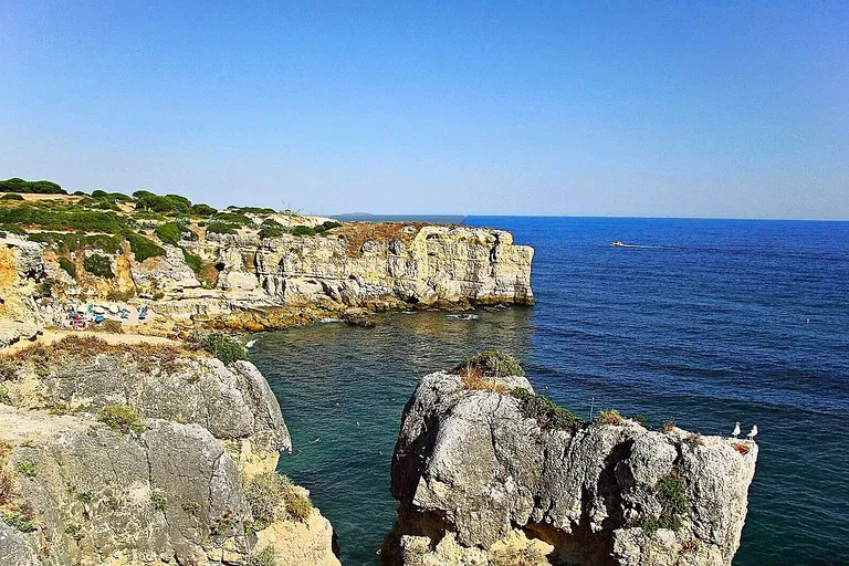 Areal recolhido da Praia da Coelha rodeado por falésias do Algarve.