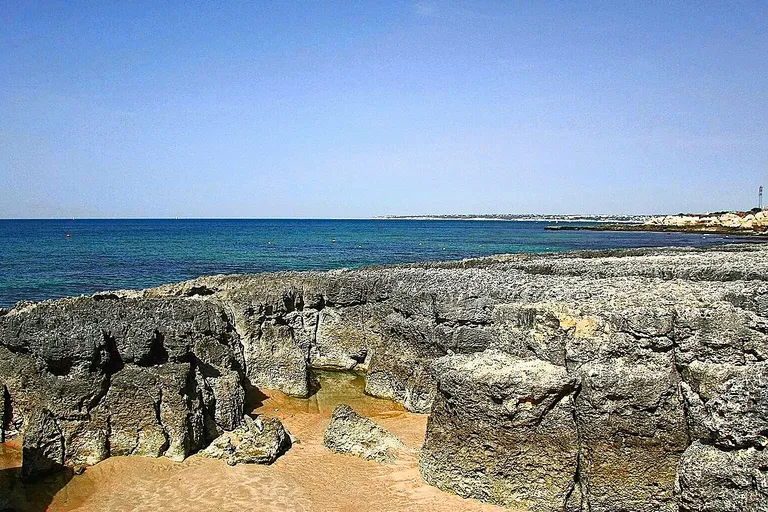 Areal dourado da Praia do Evaristo emoldurado por falésias.